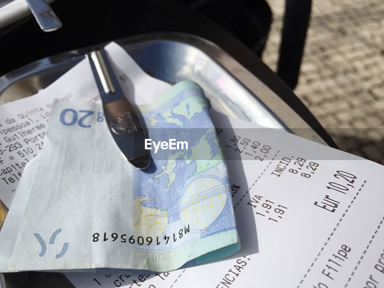 Close-up of bill with twenty euro banknote on tray