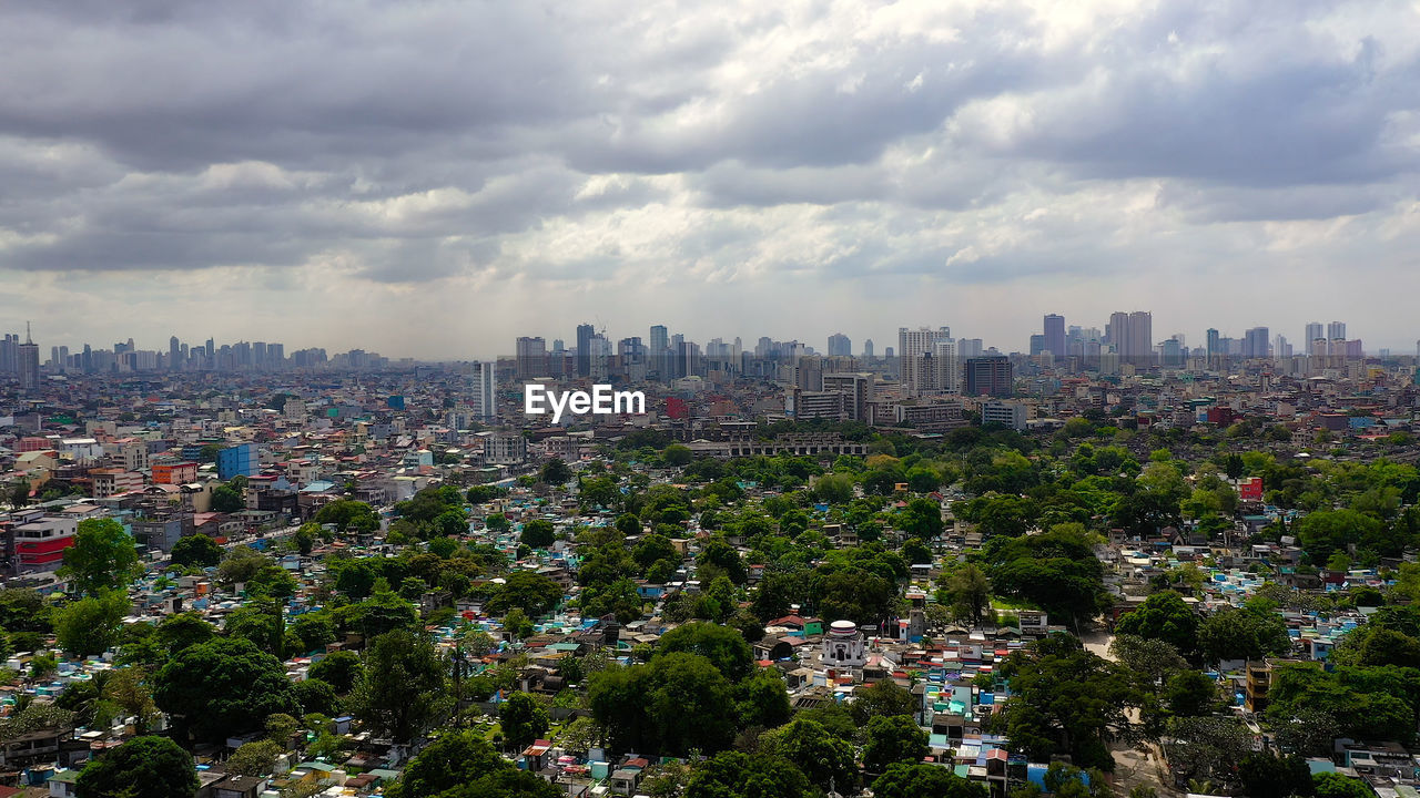 Manila north cemetery on the background of skyscrapers and modern buildings, aerial drone. 
