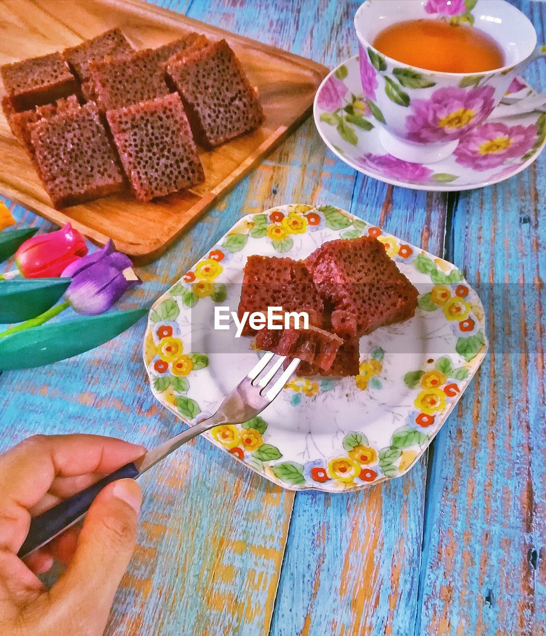 HIGH ANGLE VIEW OF HAND HOLDING CAKE