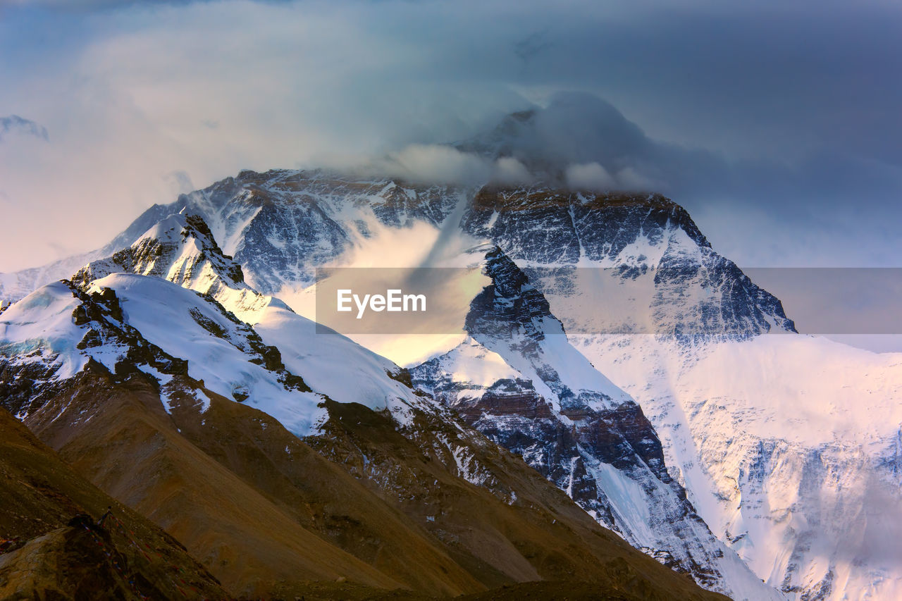 Scenic view of snowcapped mountain against cloudy sky