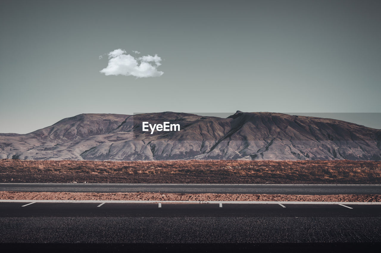 Scenic view of land and mountains against sky