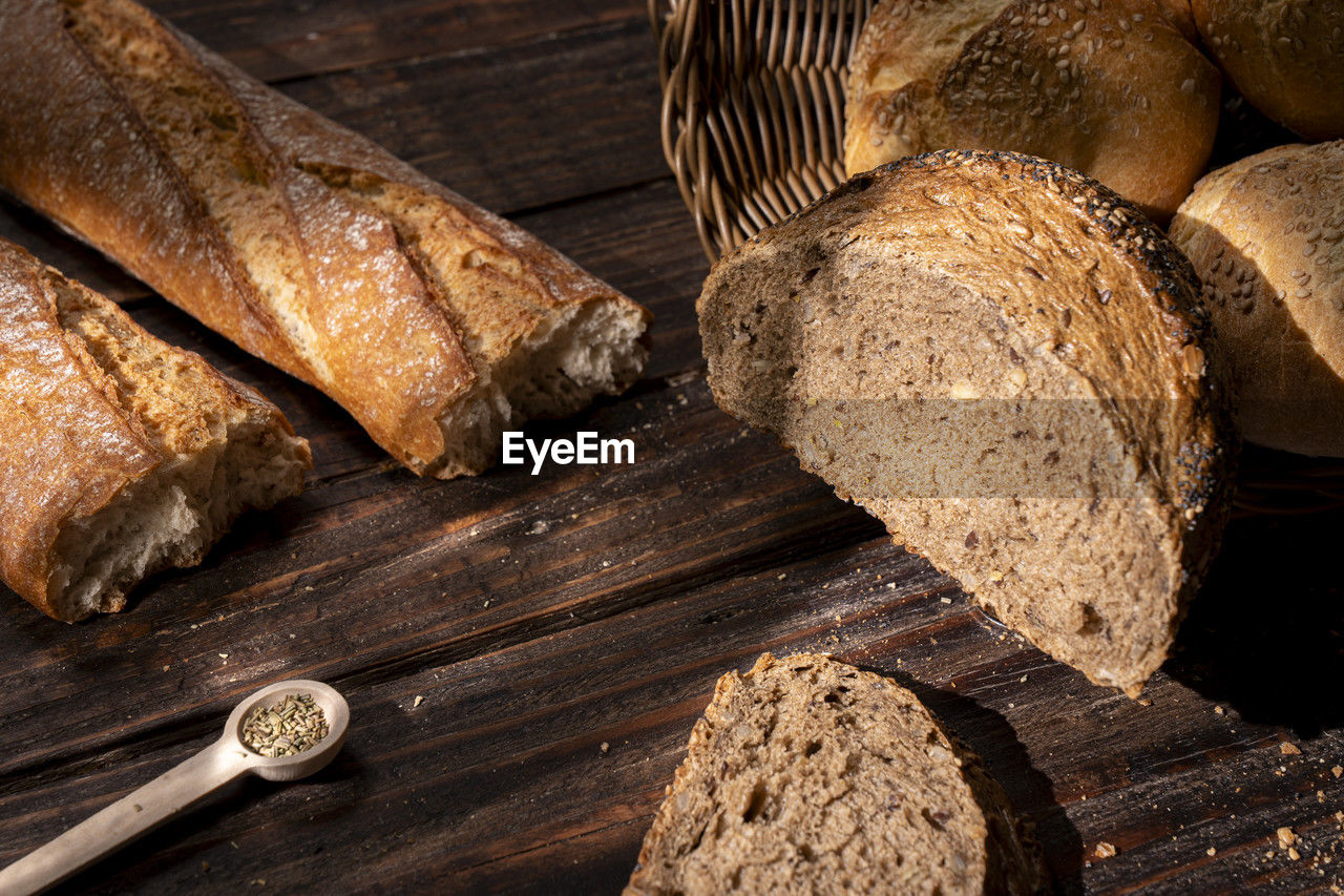 food and drink, wood, food, bread, freshness, loaf of bread, no people, healthy eating, wellbeing, baked, brown, rye bread, indoors, close-up, bakery, rustic, still life, table, store, produce, high angle view, brown bread