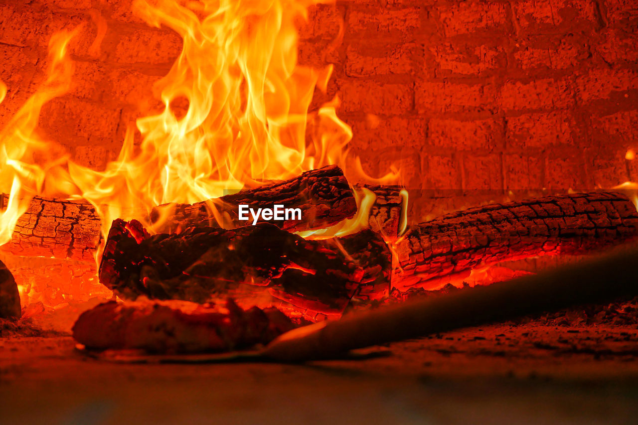 CLOSE-UP OF FIRE BURNING IN WOODEN ROOM