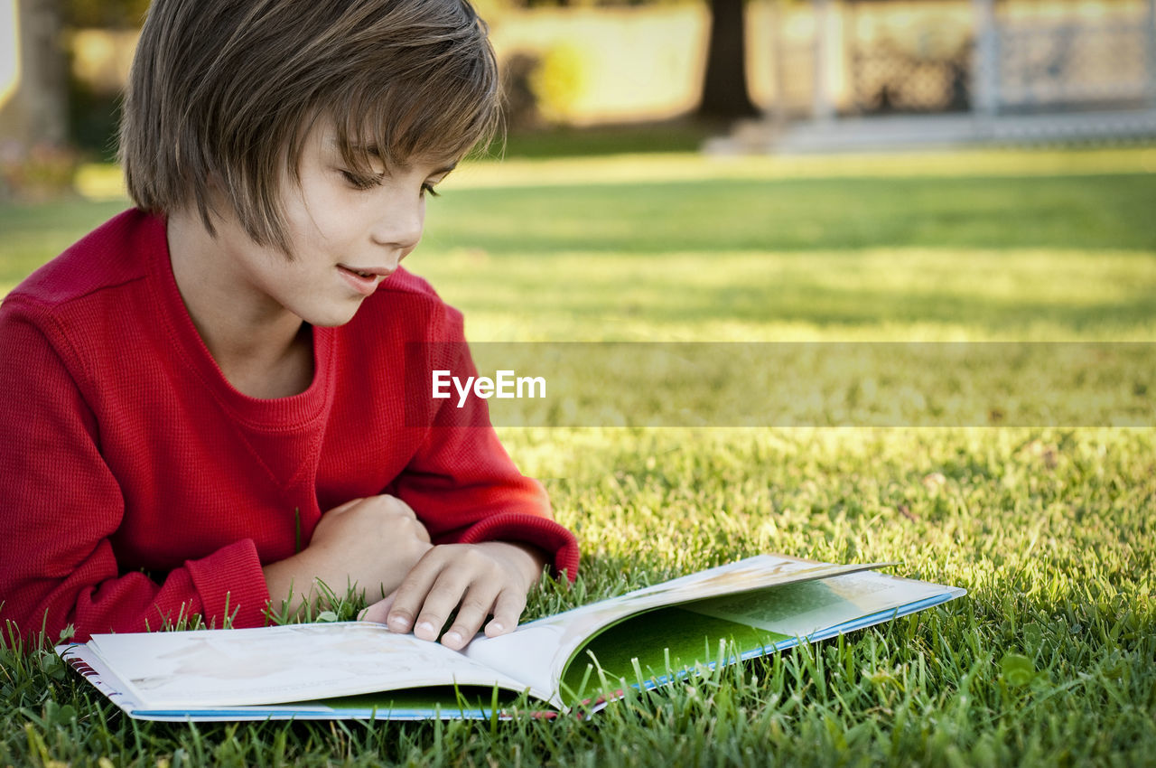 Boy reading book in park