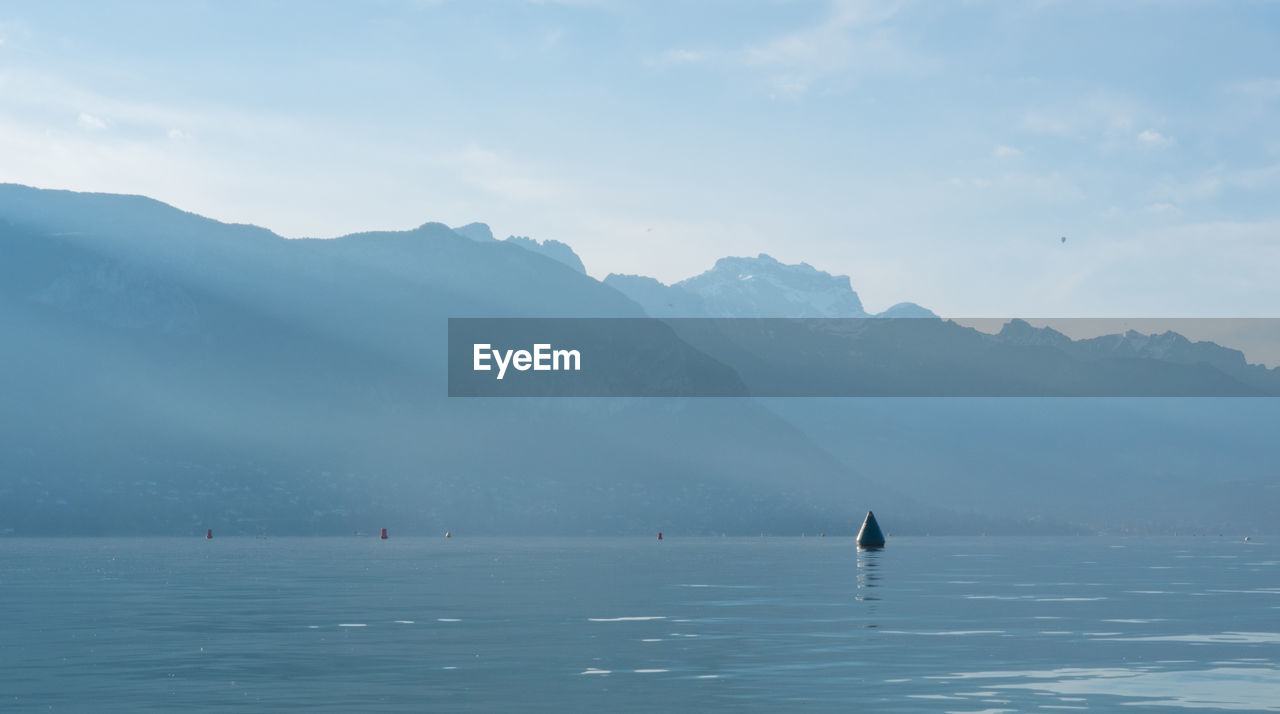 Scenic view of sea and mountains against sky