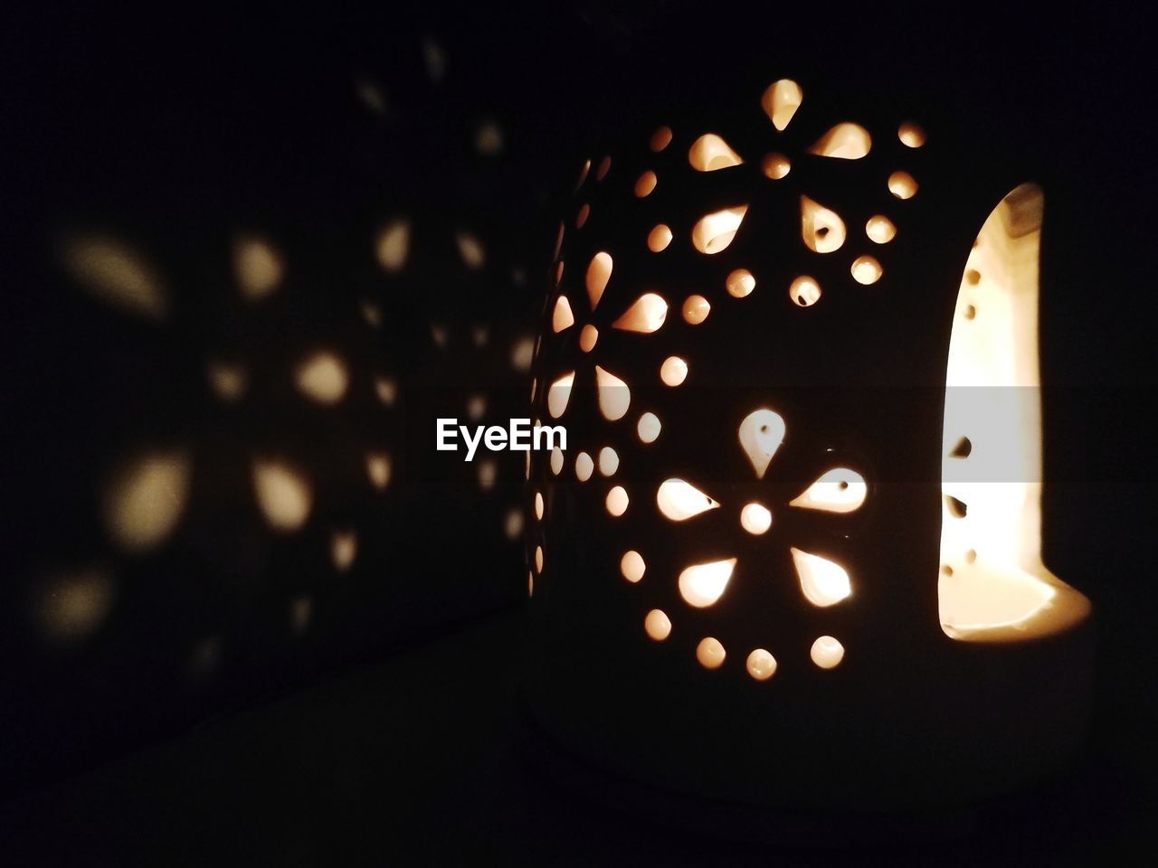 CLOSE-UP OF LIT CANDLE IN DARK