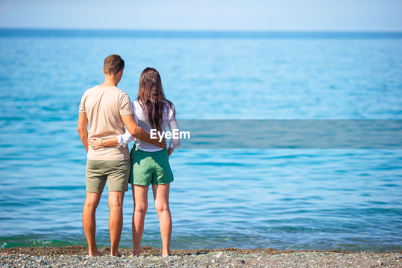 Rear view of couple standing at sea shore