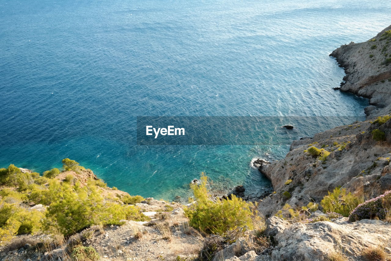 High angle view of cliff by sea against sky