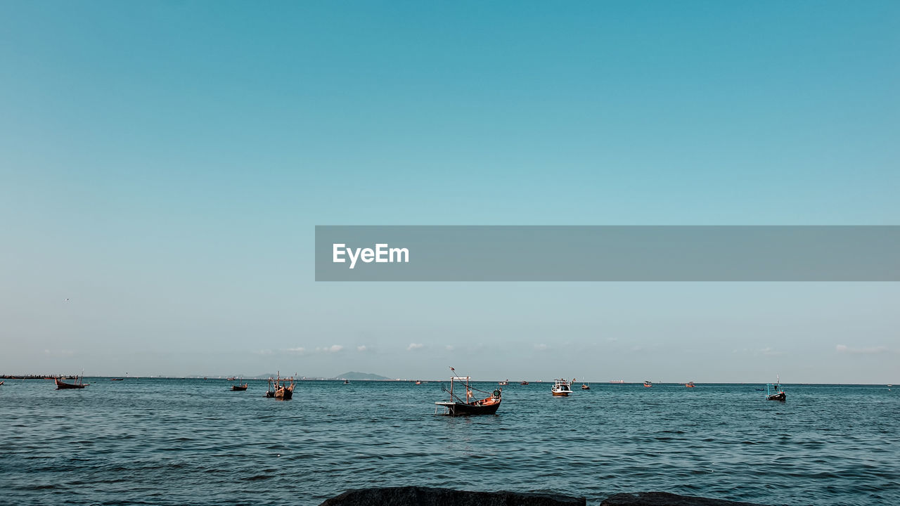 Sailboat in sea against clear sky