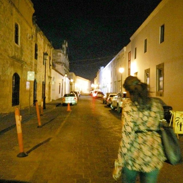 WOMAN IN ILLUMINATED CITY AT NIGHT