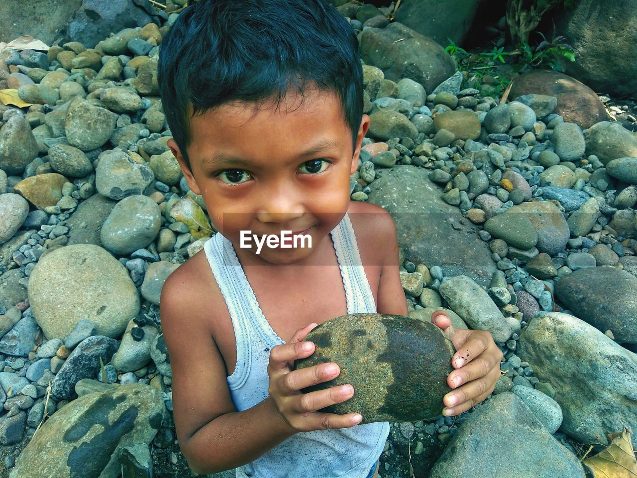 PORTRAIT OF CUTE BOY ON ROCKS