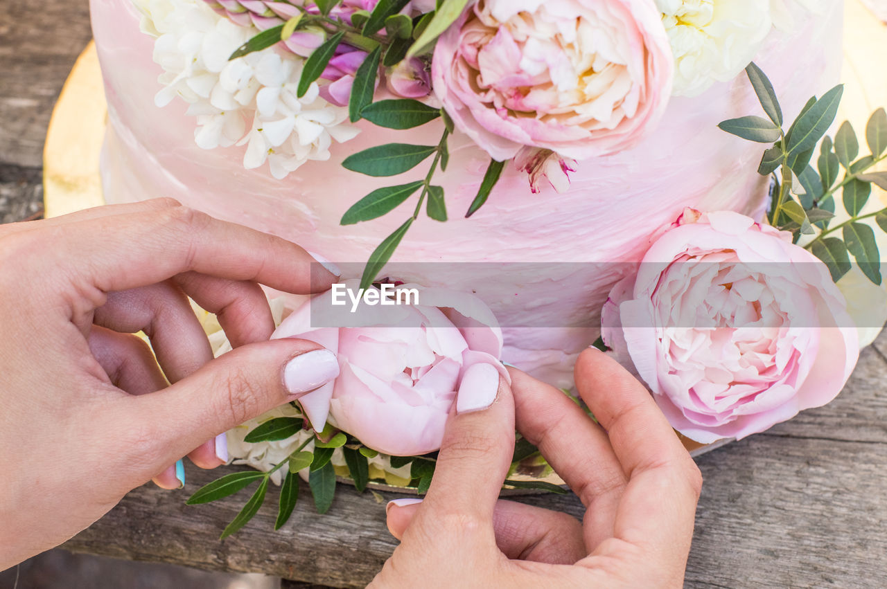 CLOSE-UP OF HAND HOLDING BOUQUET OF PINK ROSE