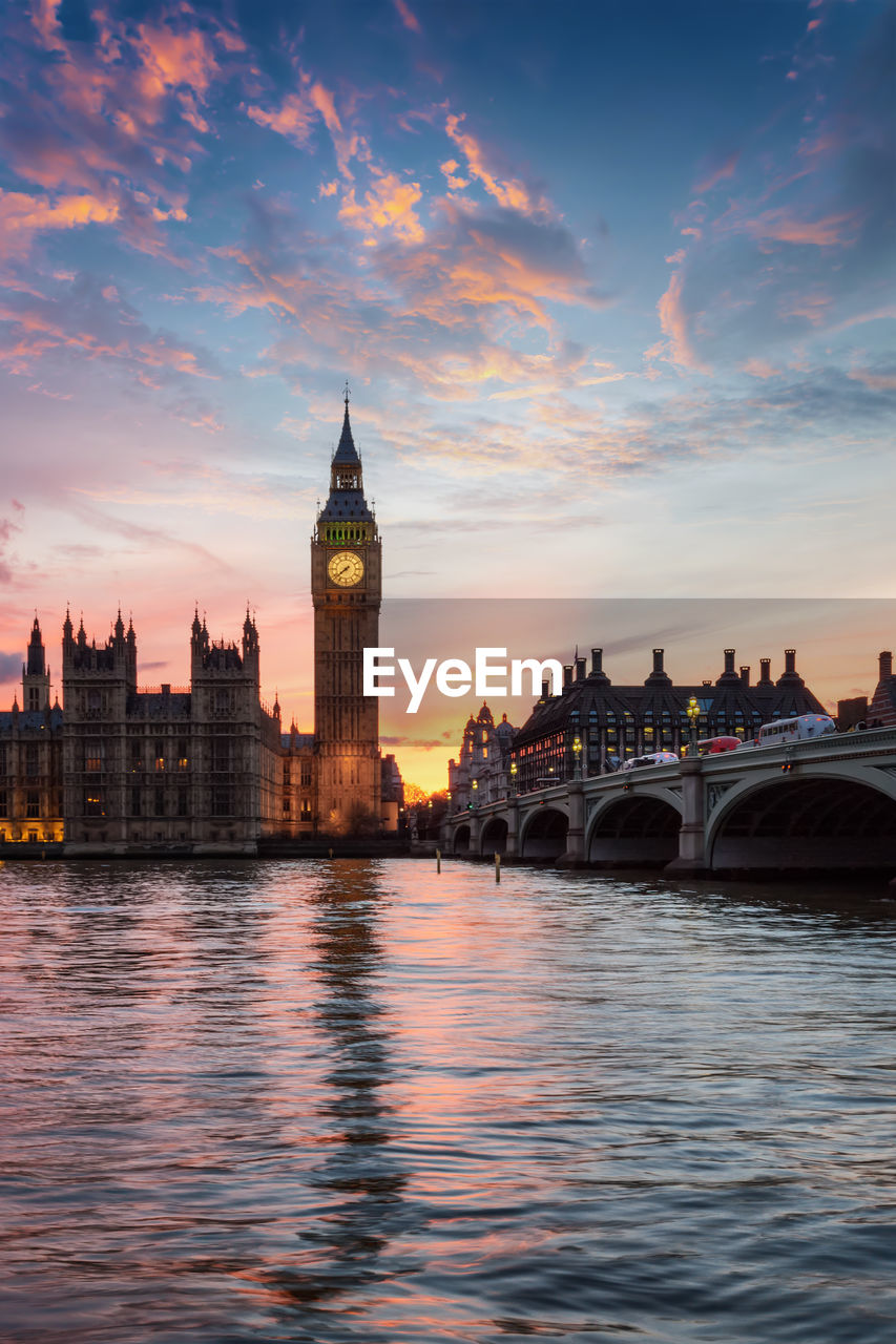 Big ben and houses of parliament by westminster bridge during sunset