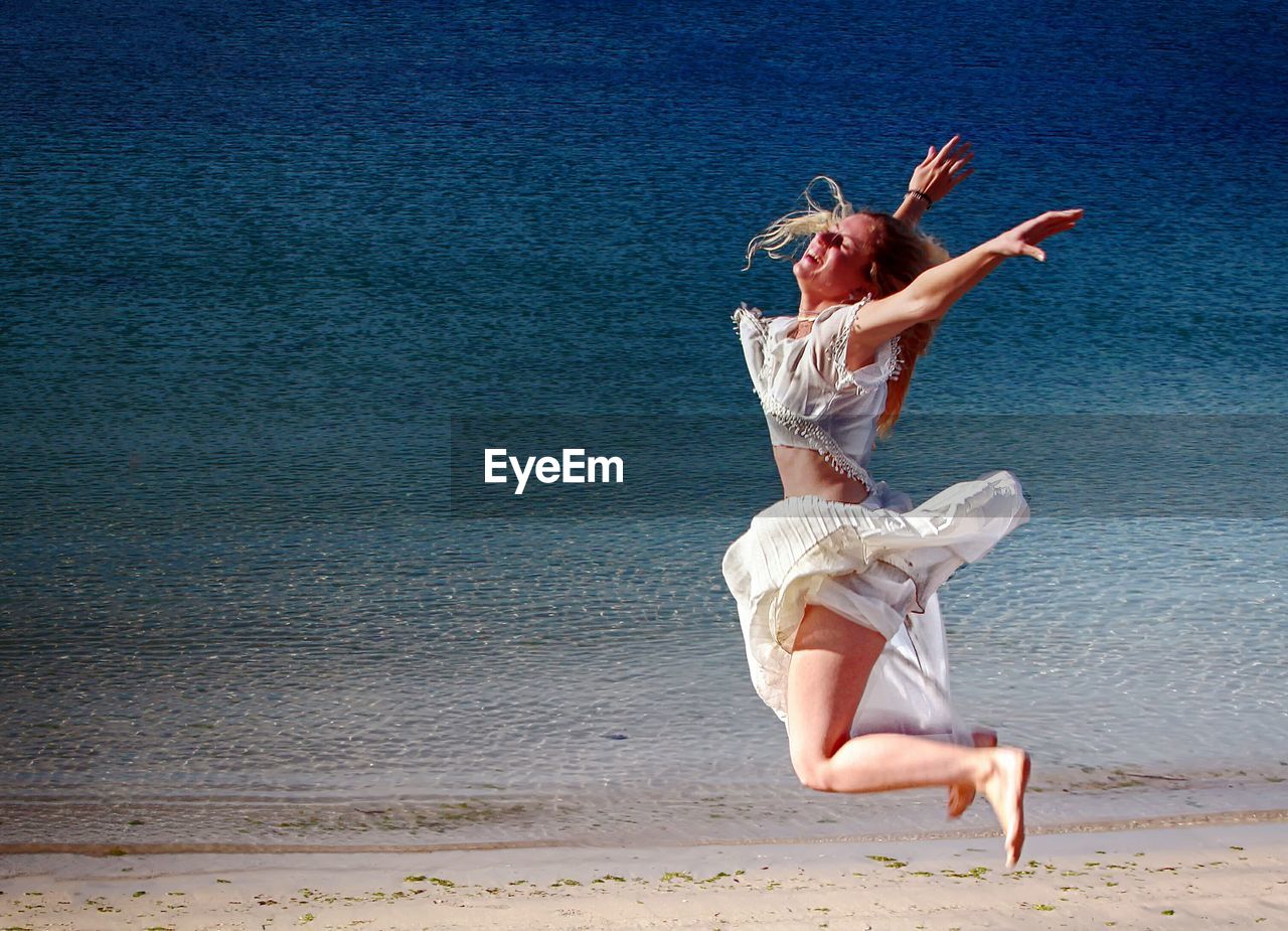 WOMAN JUMPING ON BEACH