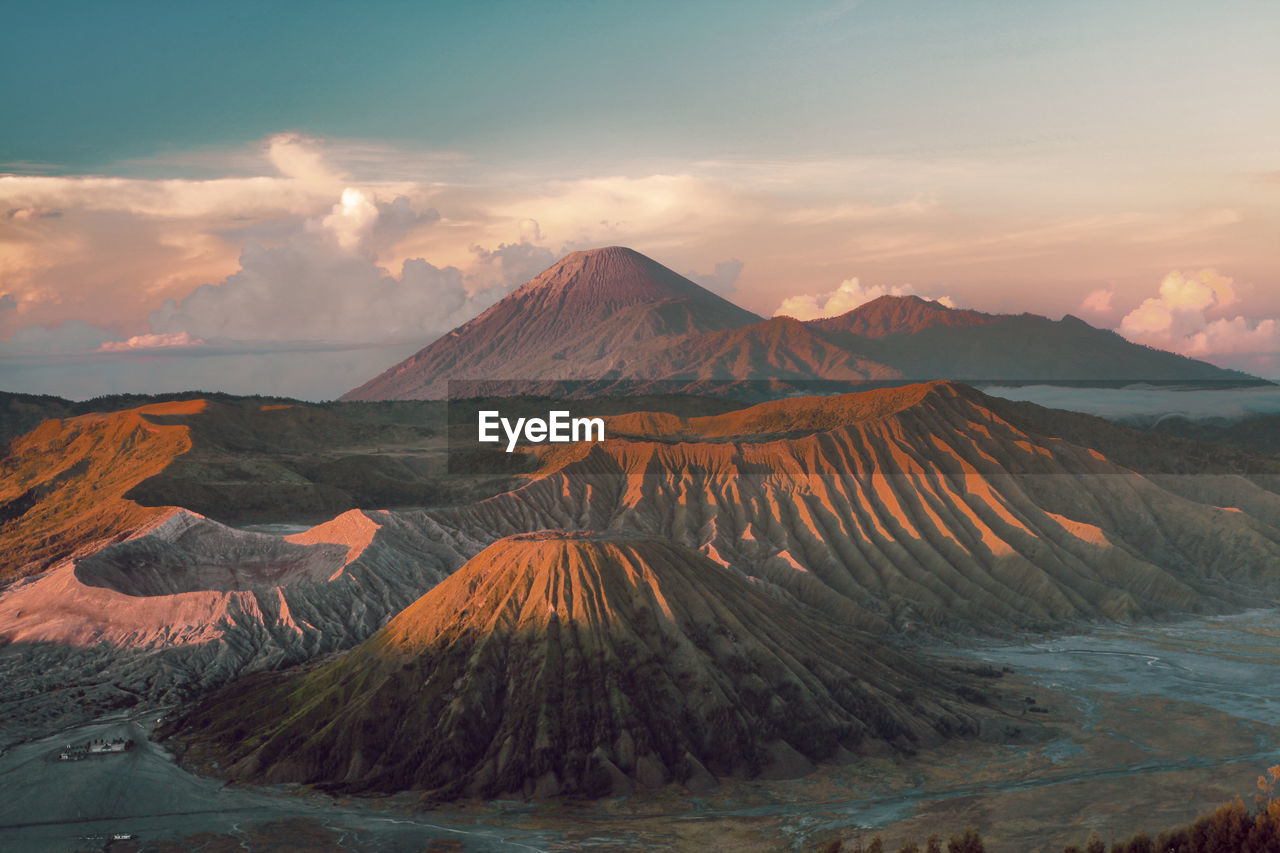 VIEW OF VOLCANIC LANDSCAPE AGAINST CLOUDY SKY