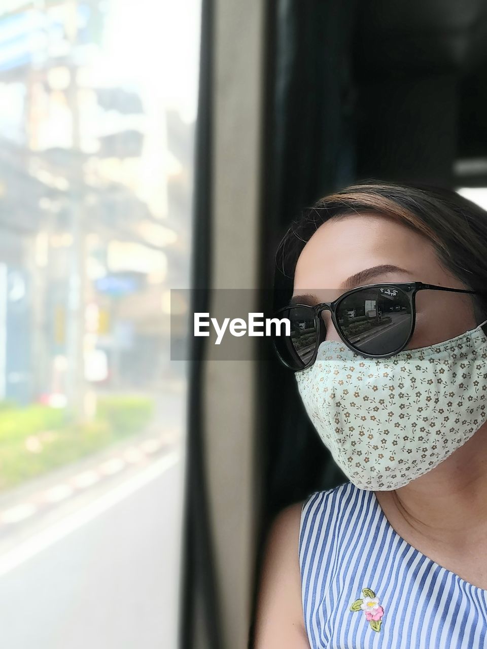 Young woman wearing sunglasses and mask
