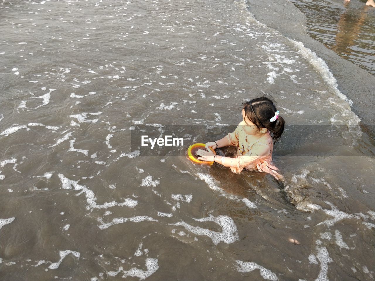 High angle view of girl playing in sea