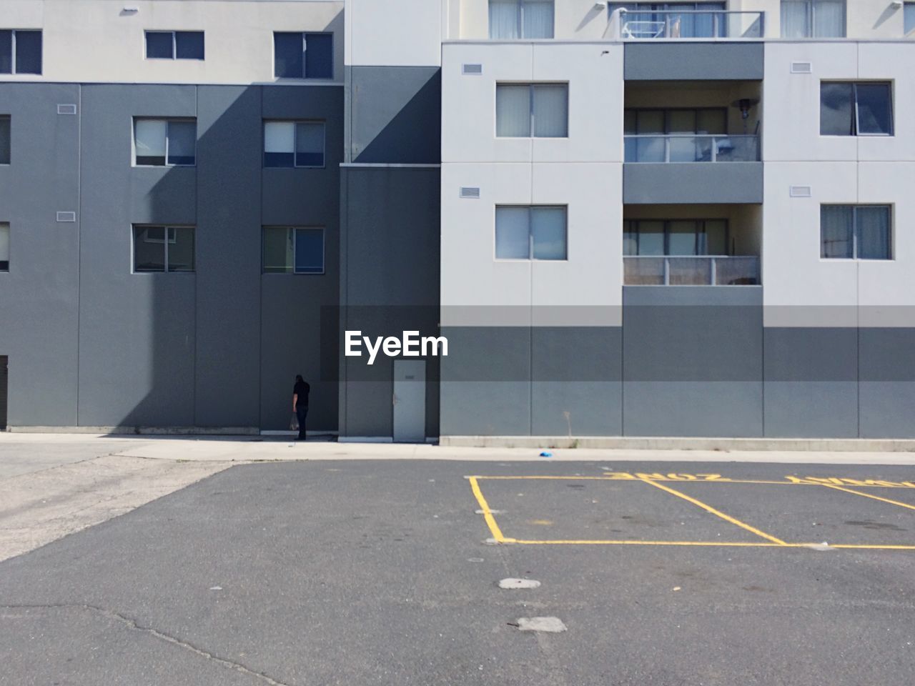Empty parking lot against building on sunny day