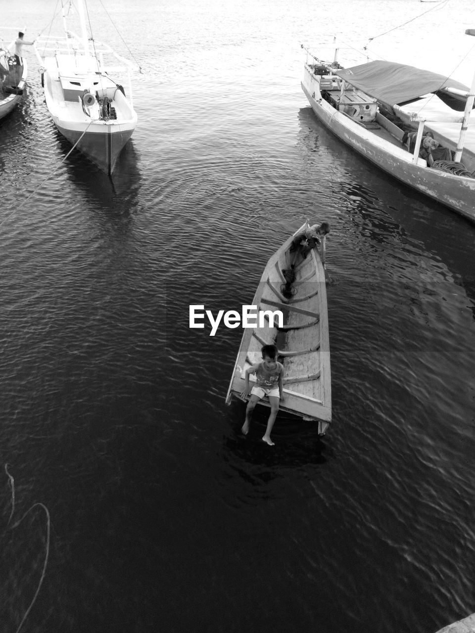 HIGH ANGLE VIEW OF MAN IN BOAT MOORED ON SEA