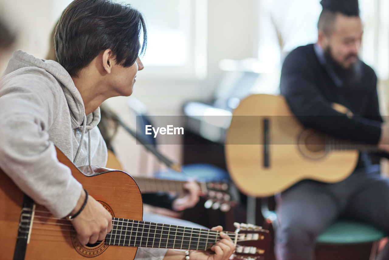 Teenage boy attending guitar lesson