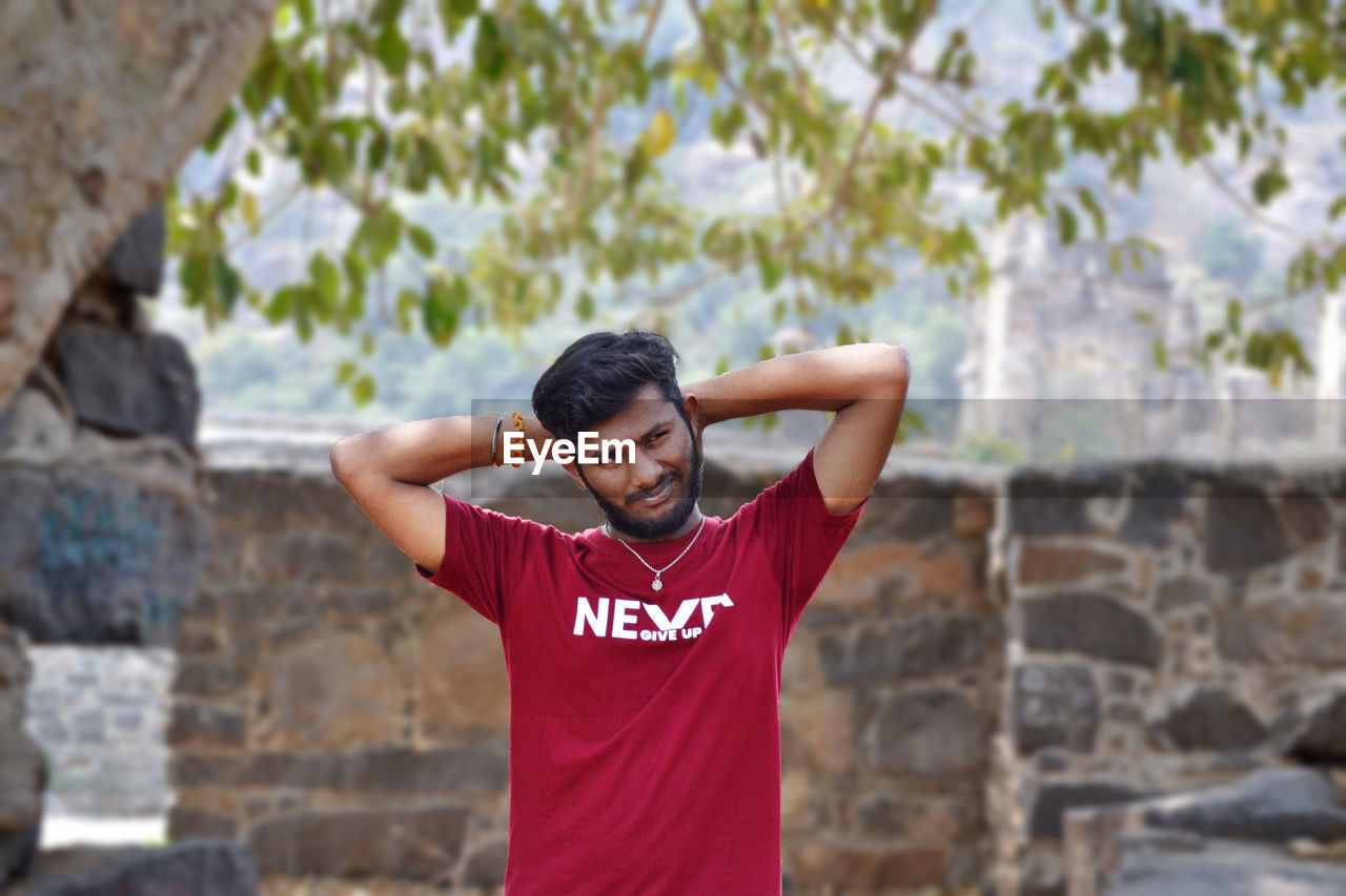 Young man standing against wall