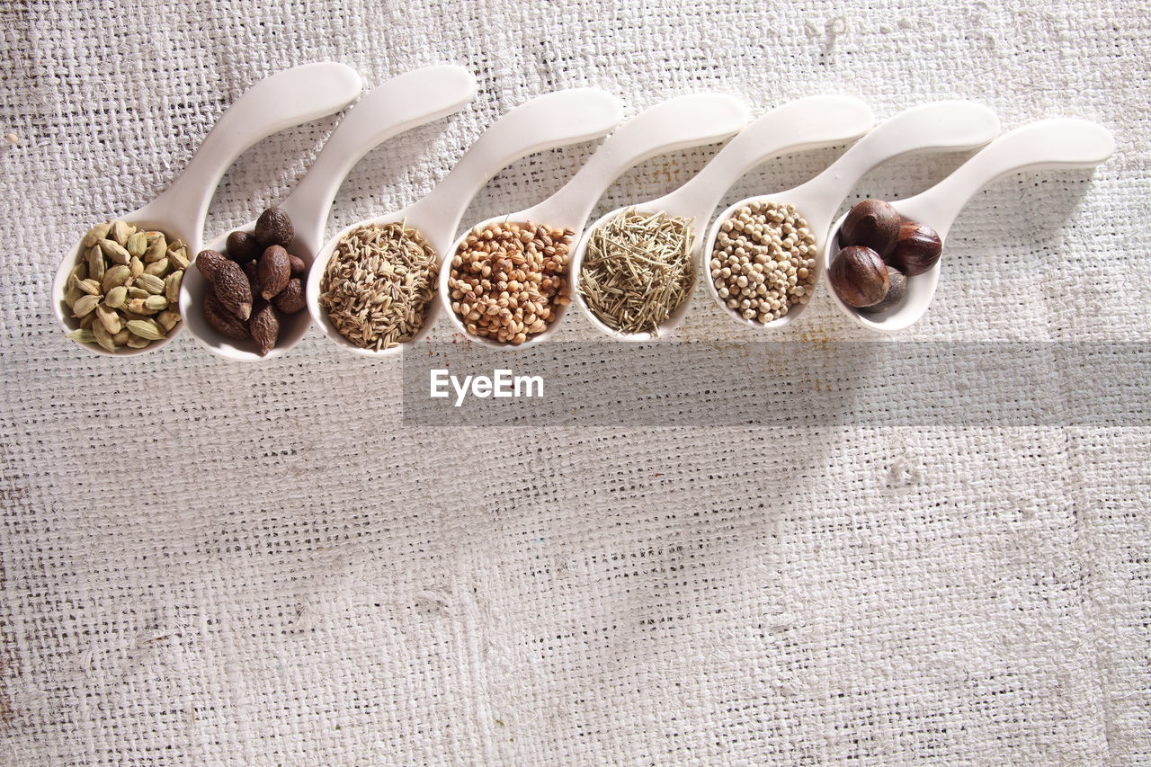 High angle view of spices in spoons on table