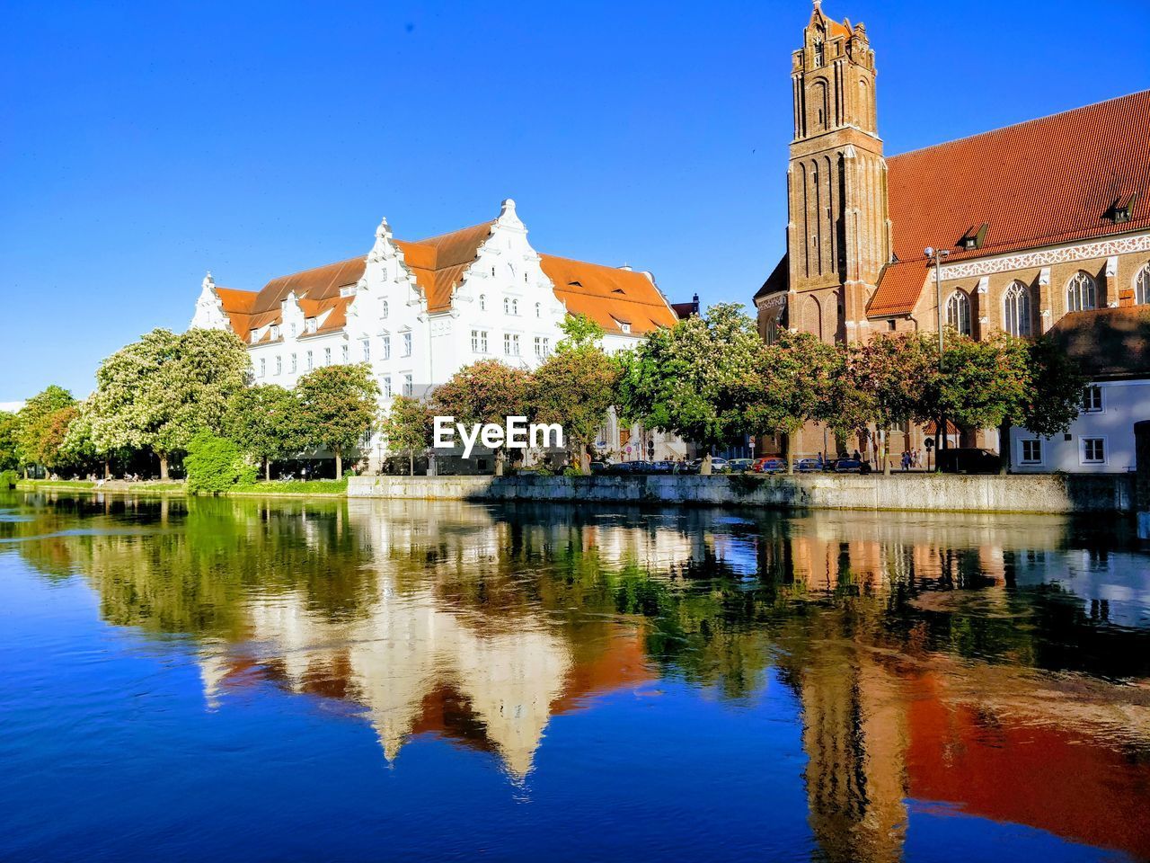 REFLECTION OF TREES AND BUILDINGS IN LAKE