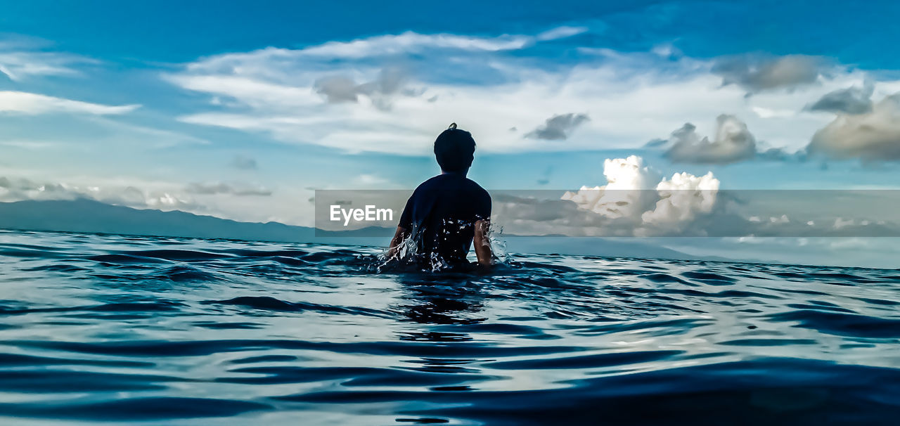 REAR VIEW OF MAN IN SEA