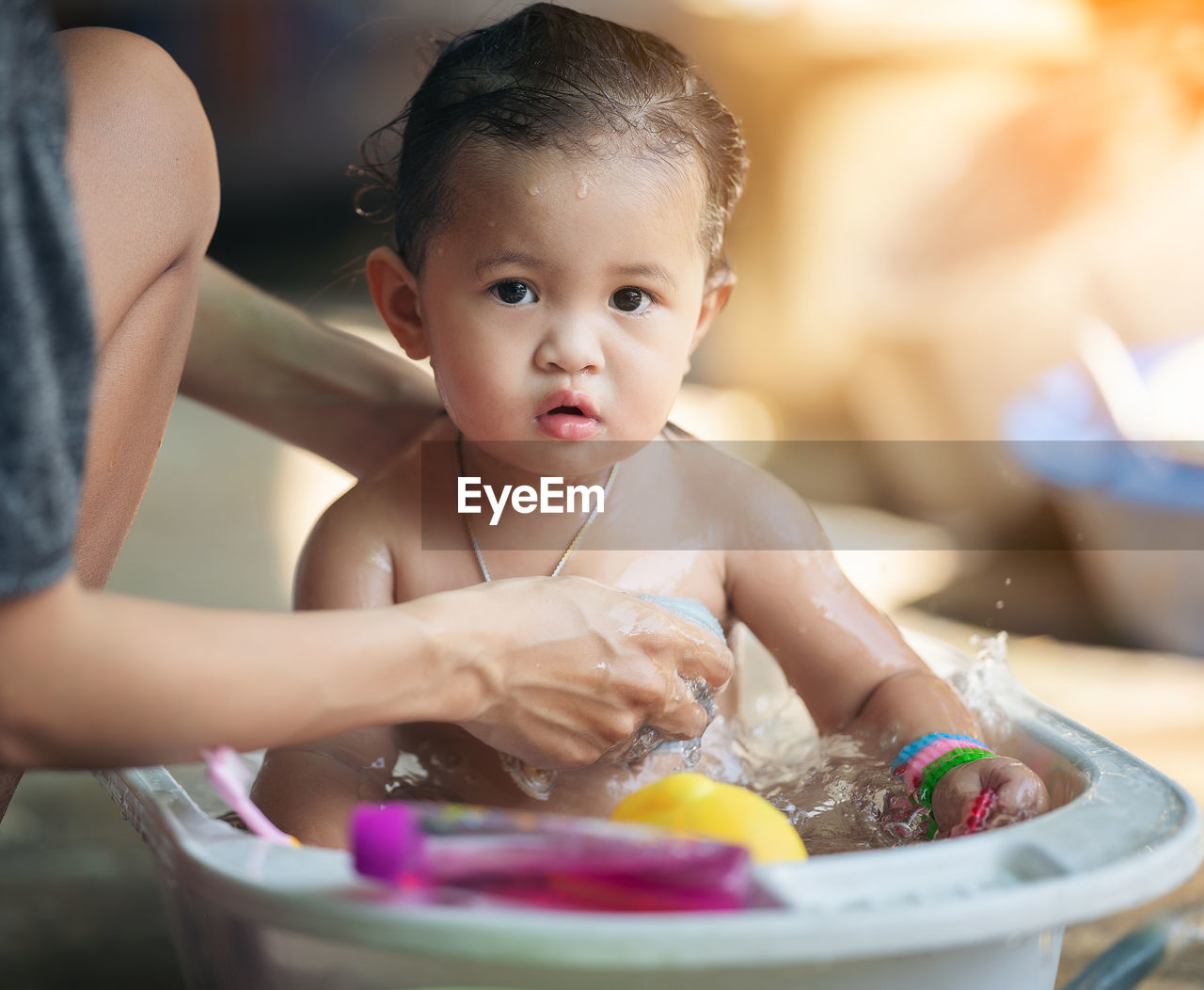 Mother bathes the kid concept. adorable girl in bathtub with fluffy soap bubble. mom bathing infant. 