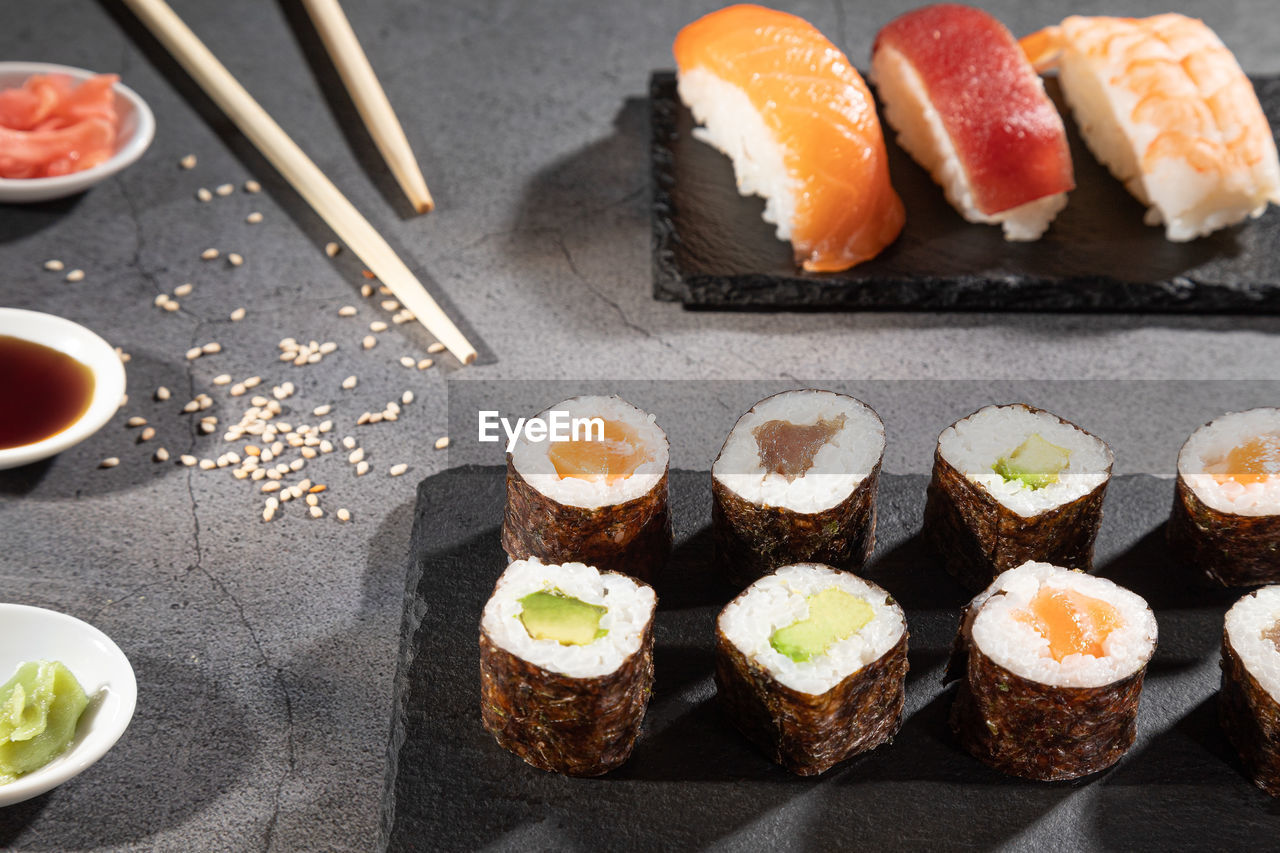 Closeup of fresh variety of sushi on dark background.