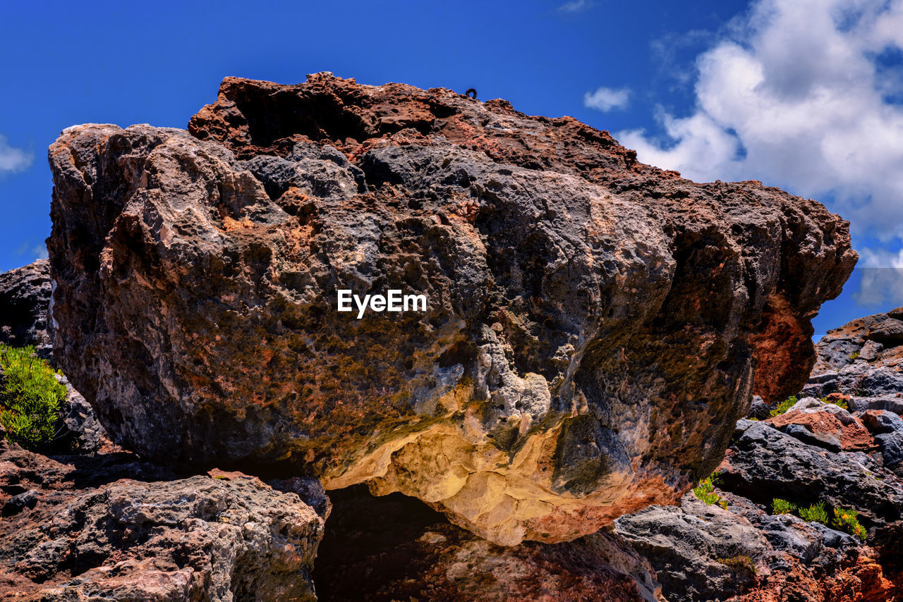 LOW ANGLE VIEW OF ROCK FORMATION ON LAND AGAINST SKY