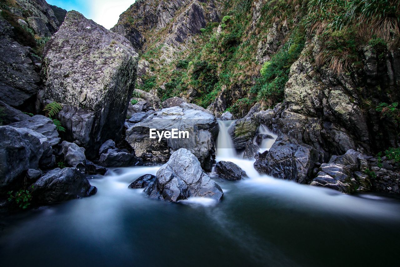 SCENIC VIEW OF STREAM FLOWING THROUGH ROCKS