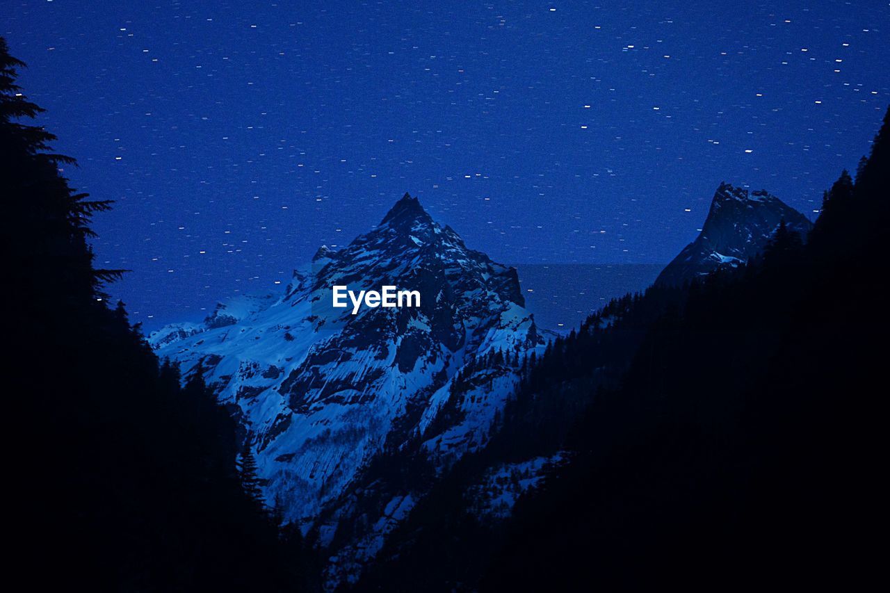 LOW ANGLE VIEW OF SNOWCAPPED MOUNTAINS AGAINST SKY