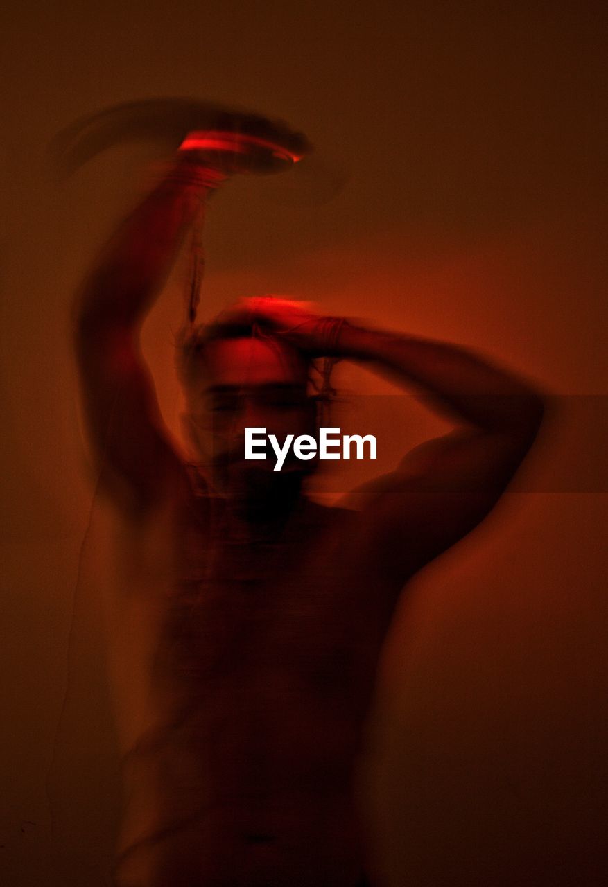 Blurred motion of man dancing in darkroom