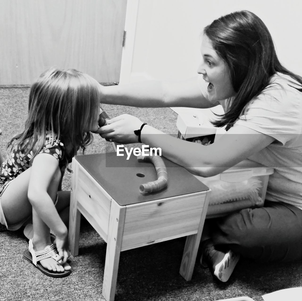Mother teaching daughter speech therapy at home