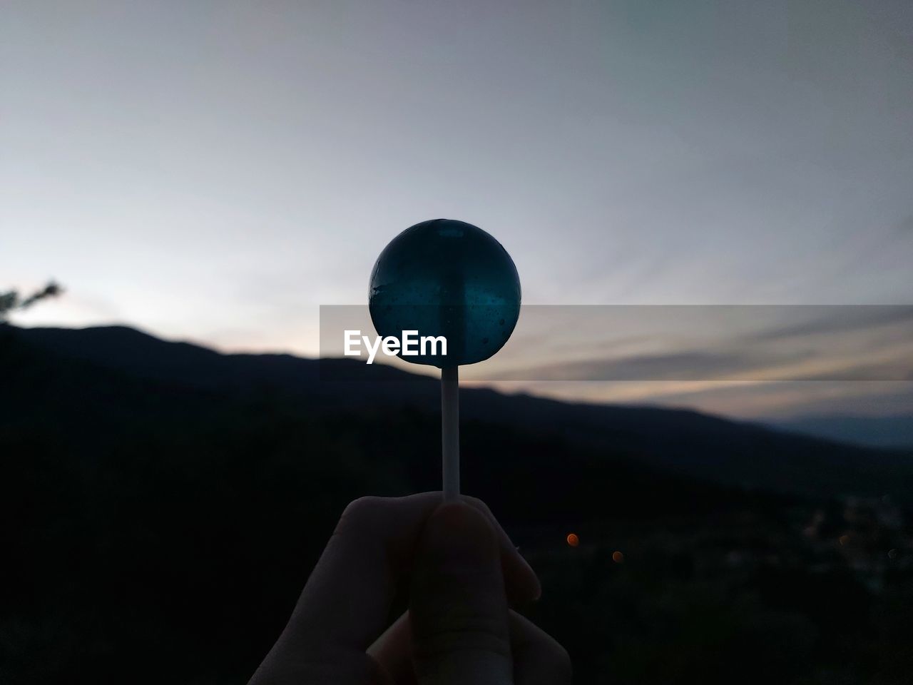 PERSON HOLDING UMBRELLA AGAINST SKY