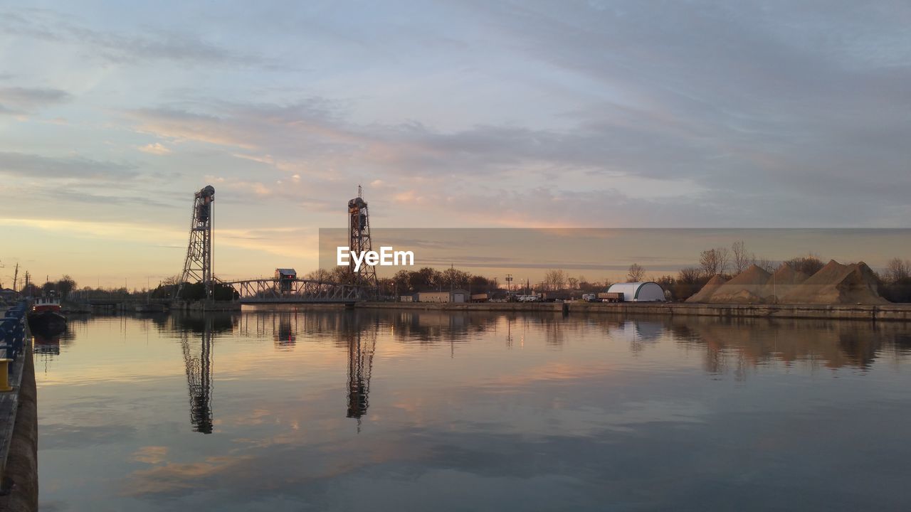 Bridge over river against sky during sunset