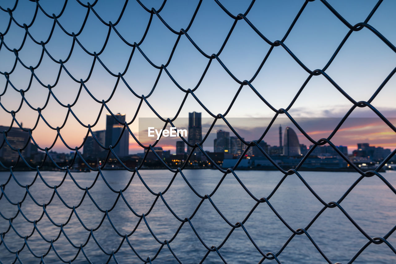 CITY SEEN THROUGH CHAINLINK FENCE