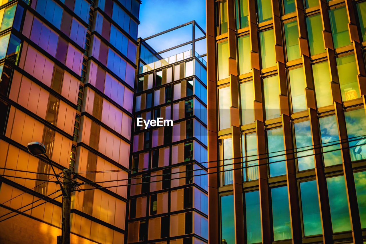 Low angle view of modern glass building against sky