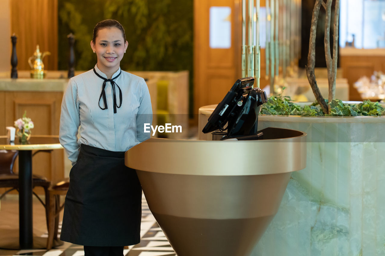 Portrait of receptionist standing in hotel