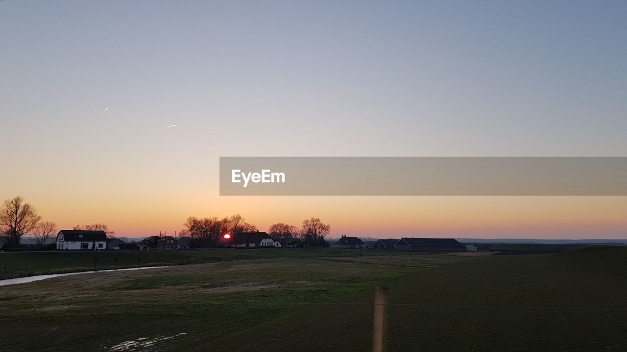 SCENIC VIEW OF LANDSCAPE AGAINST ORANGE SKY