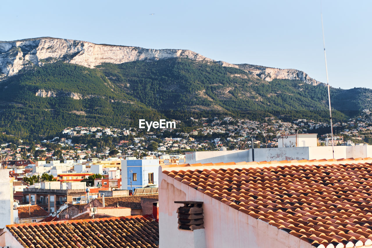 Town by mountain against clear sky