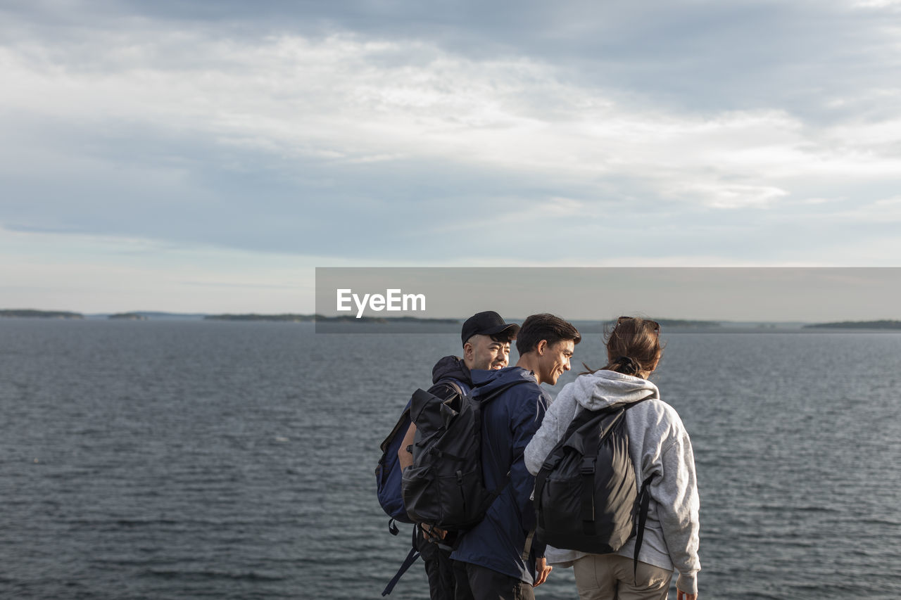 Friends standing together at sea