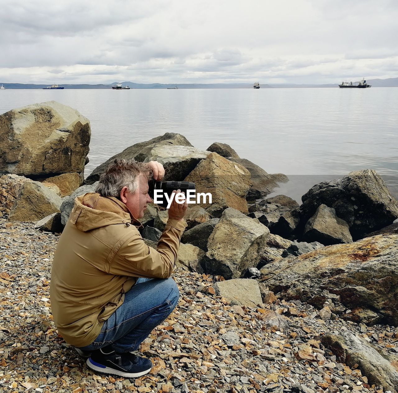 Photographer taking a picture on the rocky beach