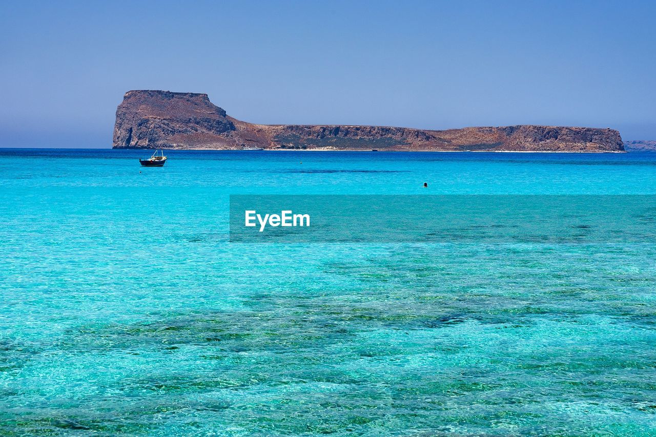 Scenic view of sea against clear blue sky