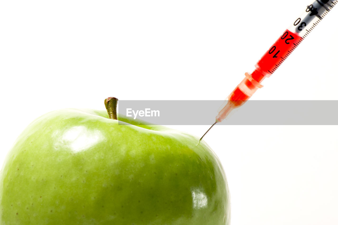 CLOSE-UP OF APPLE ON RED BACKGROUND