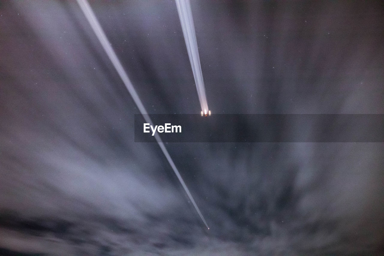 LOW ANGLE VIEW OF LIGHT TRAILS AGAINST SKY