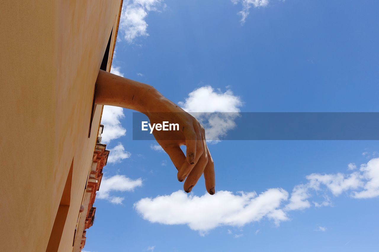 LOW ANGLE VIEW OF PERSON AGAINST BLUE SKY