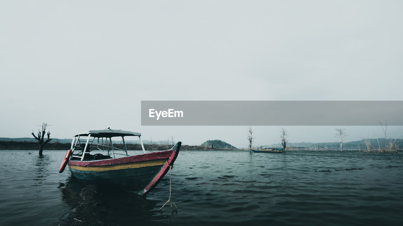 BOAT IN SEA AGAINST SKY