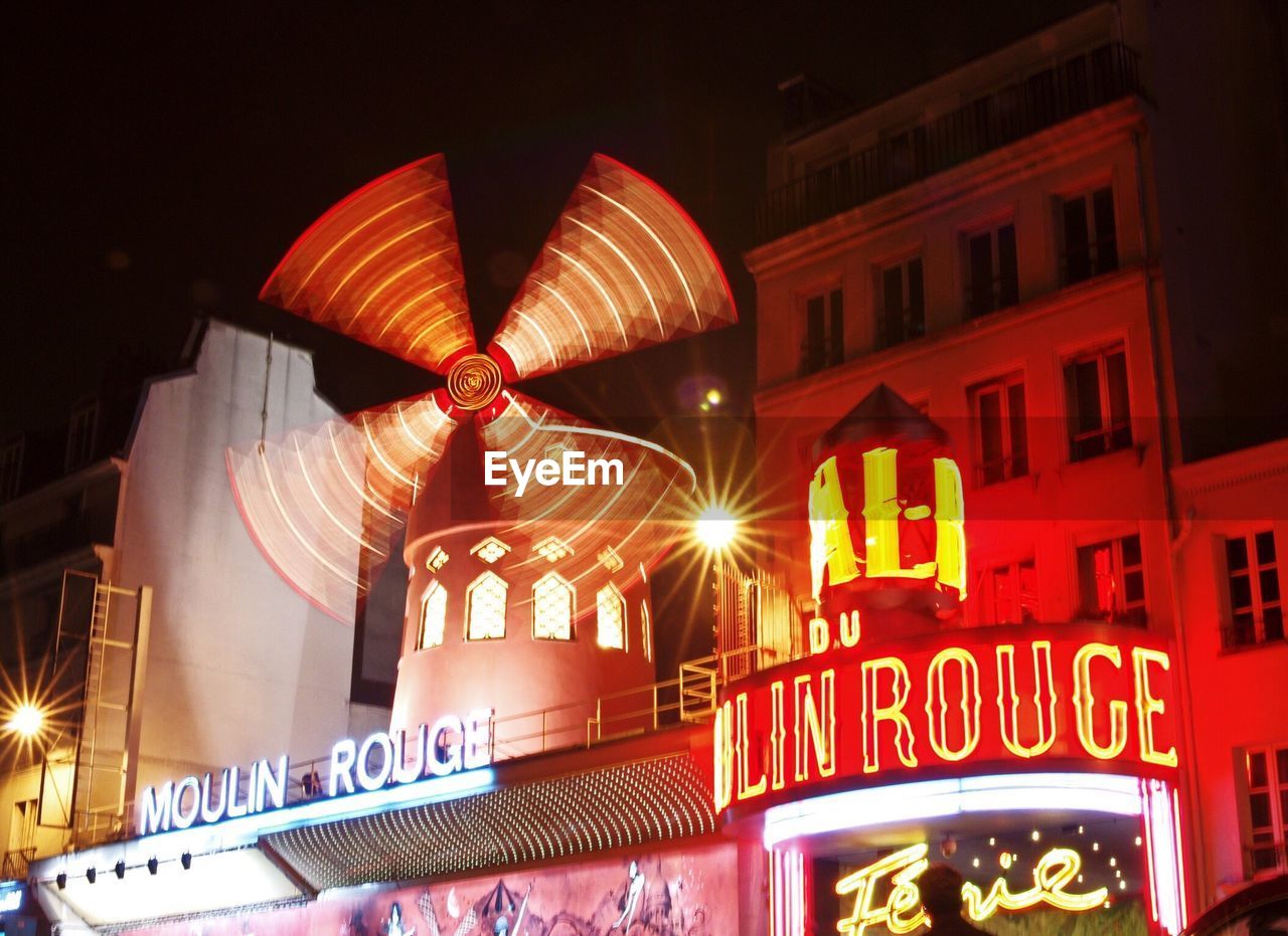 LOW ANGLE VIEW OF ILLUMINATED BUILDING AT NIGHT